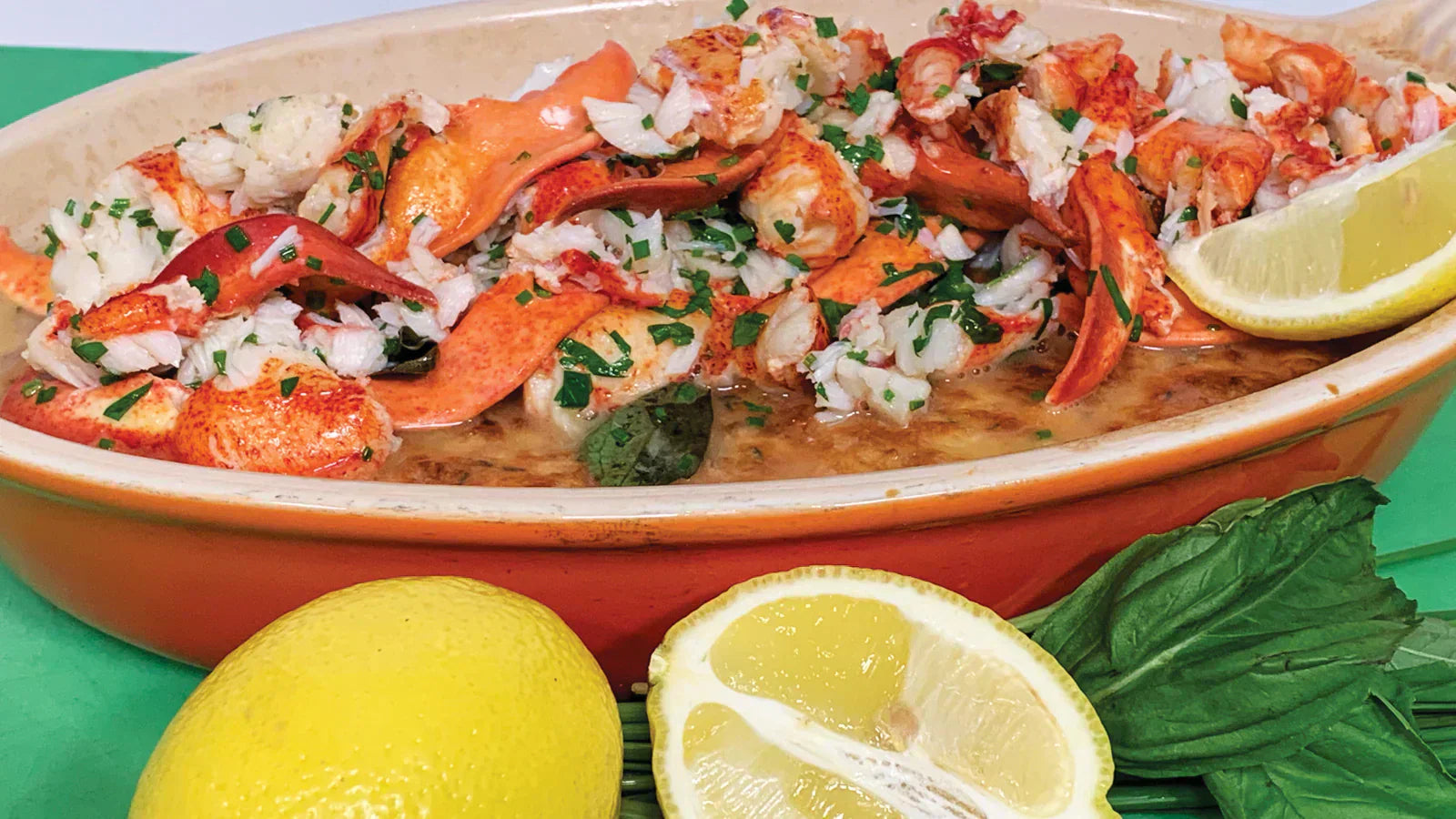 Creamy corn pudding topped with buttery Maine lobster chunks, showcasing a rich, sweet and savory pairing.