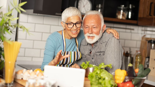 An older couple joyfully preparing a meal together in their kitchen, sharing a moment of connection, perfect for creating lasting memories.