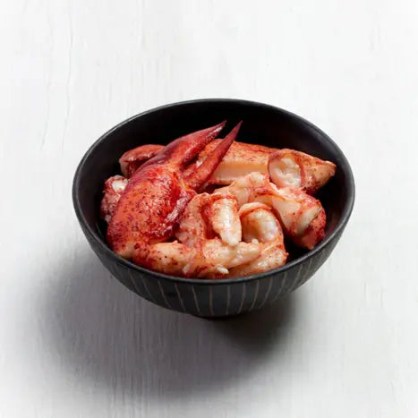Bowl of flash-frozen Maine lobster claw and knuckle meat, showcasing rich red color and tender texture-perfect for cooking or serving chilled.