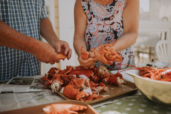 A couple preparing lobsters to make a delightful afternoon for their guests.