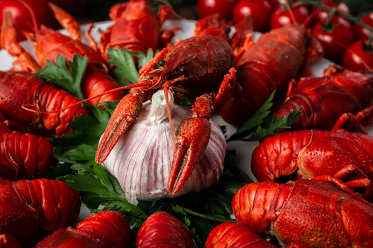 Garnished red lobsters from Get Maine Lobsters after cooking served on a plate with garlic. 