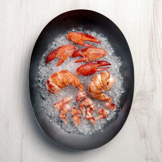 Get Maine Lobster claw, tail, and knuckle meat arranged on crushed ice in a black oval platter, overhead view.