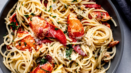 A plate of Lobster Piccata made from fresh Maine lobster, topped with a lemony caper sauce.