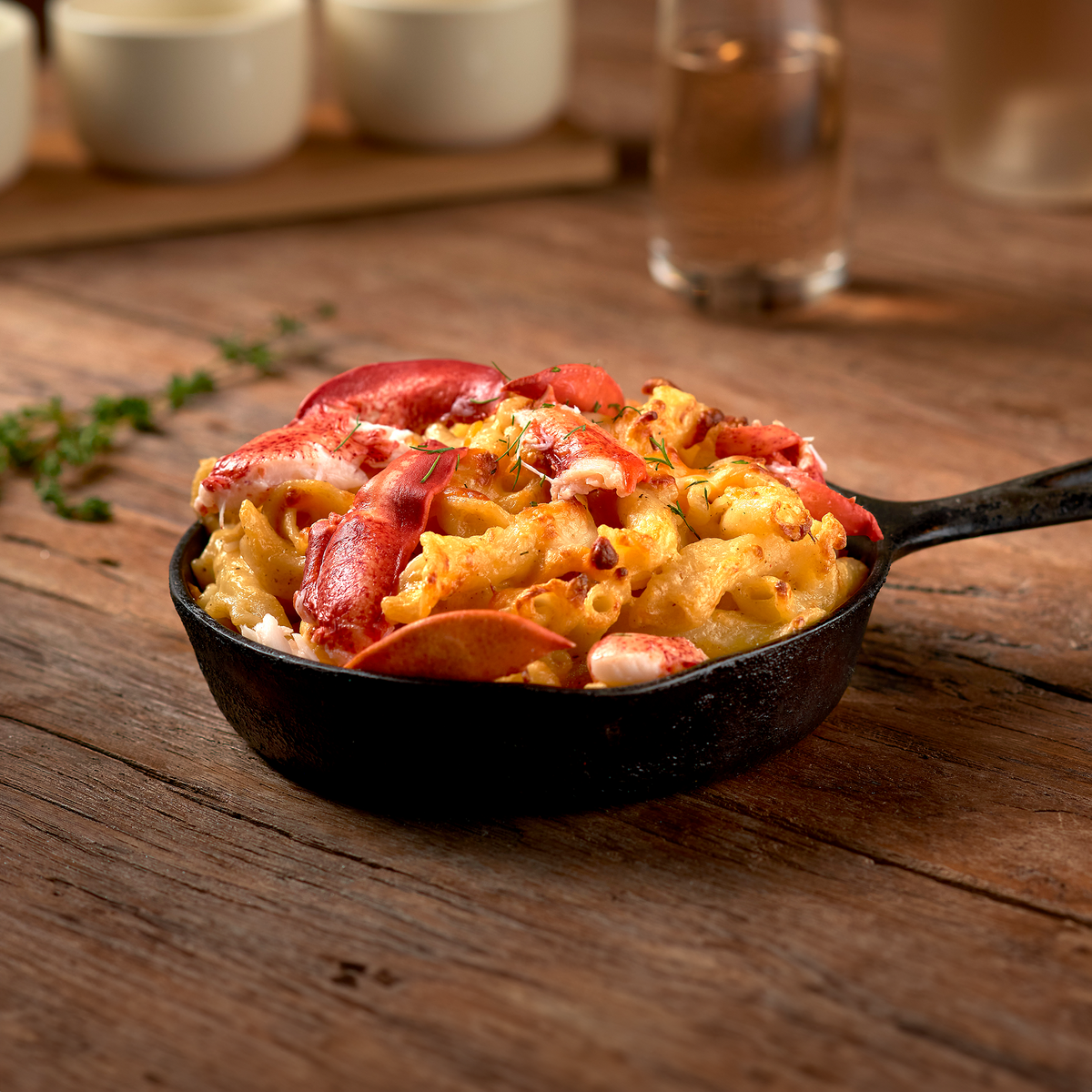 Decadent Maine lobster mac and cheese, featuring creamy cheese sauce and tender lobster chunks, served in a gourmet baked dish.