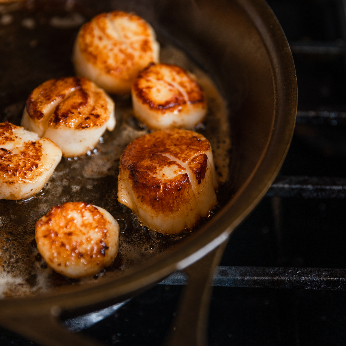 Scallops being cooked in a pan.